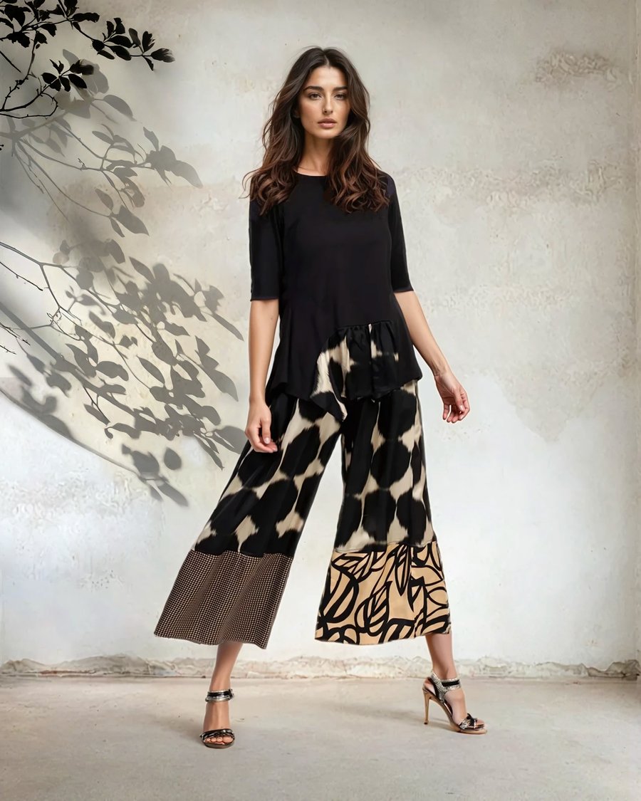 Model in black top and printed wide-leg pants, walking