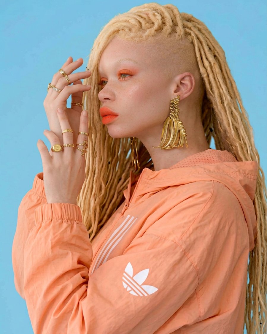 Model in orange jacket with jewelry, profile